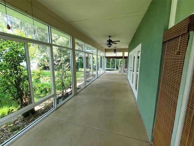 unfurnished sunroom featuring ceiling fan