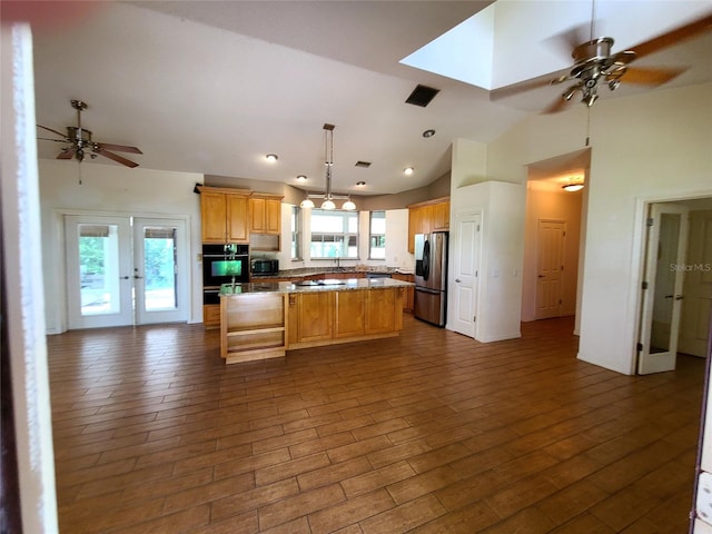 kitchen with visible vents, a ceiling fan, a kitchen island, dark wood finished floors, and appliances with stainless steel finishes