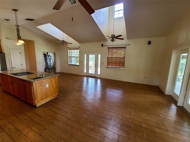 kitchen featuring dark wood-style floors, a skylight, ceiling fan, black electric cooktop, and open floor plan