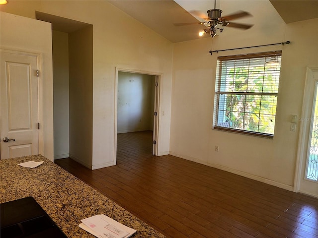 unfurnished room with baseboards, lofted ceiling, wood finished floors, and a ceiling fan