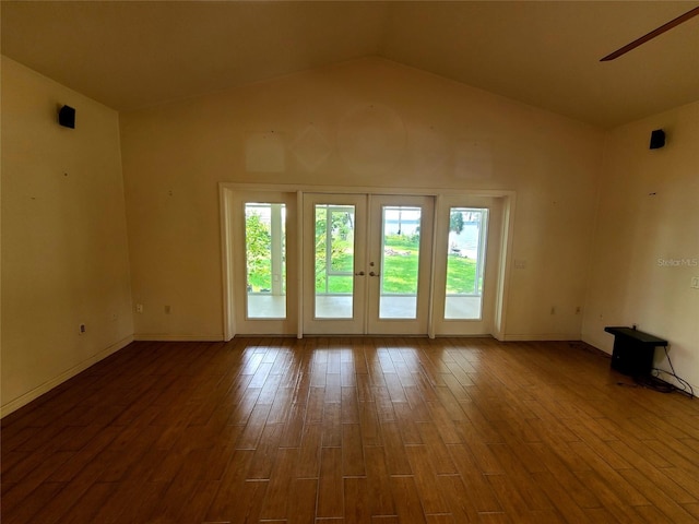 unfurnished room with lofted ceiling, wood finished floors, baseboards, and french doors