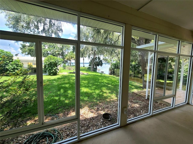 doorway featuring concrete flooring, a water view, and a wealth of natural light