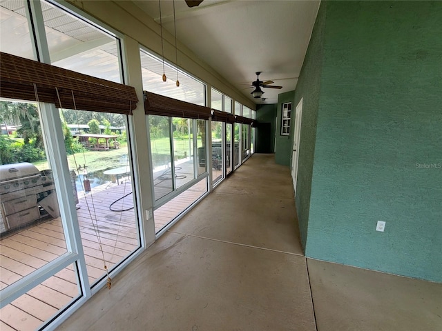 unfurnished sunroom featuring ceiling fan