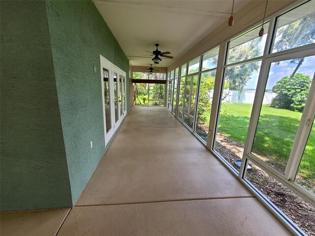 unfurnished sunroom featuring plenty of natural light and ceiling fan