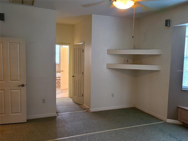 carpeted spare room with a ceiling fan, visible vents, and baseboards