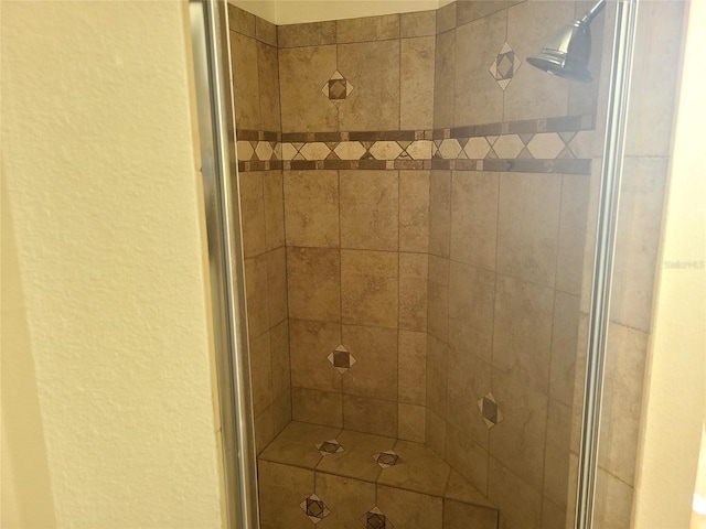 room details featuring a stall shower and a textured wall