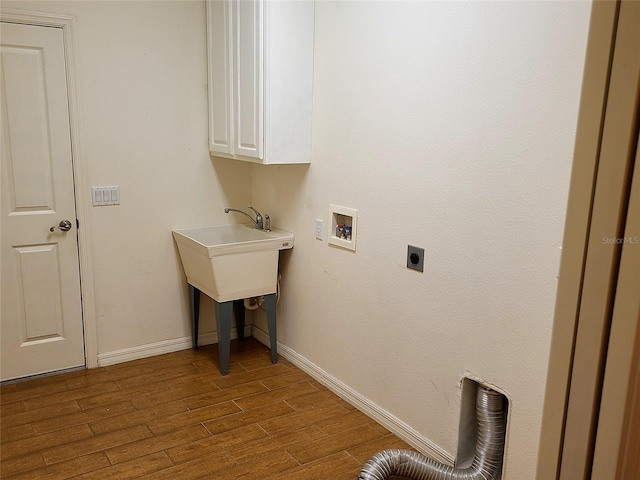 clothes washing area featuring hardwood / wood-style floors, hookup for a washing machine, cabinets, and hookup for an electric dryer