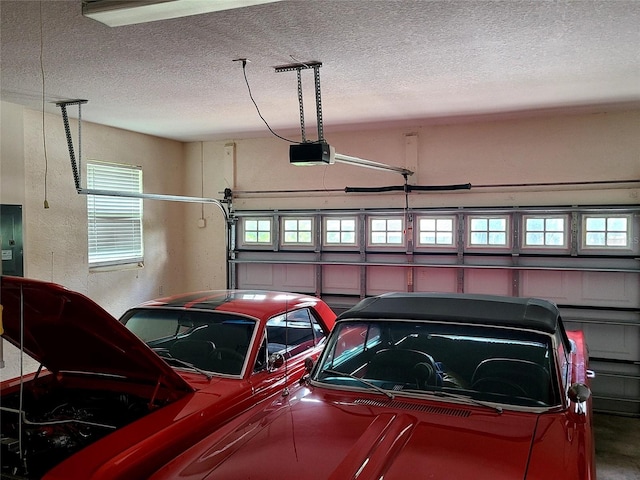 garage featuring electric panel, a garage door opener, and a textured wall