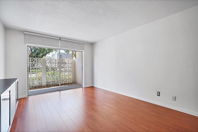 spare room featuring dark hardwood / wood-style flooring and a textured ceiling