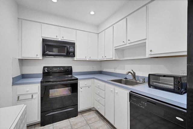 kitchen featuring black appliances, white cabinetry, light tile patterned floors, and sink