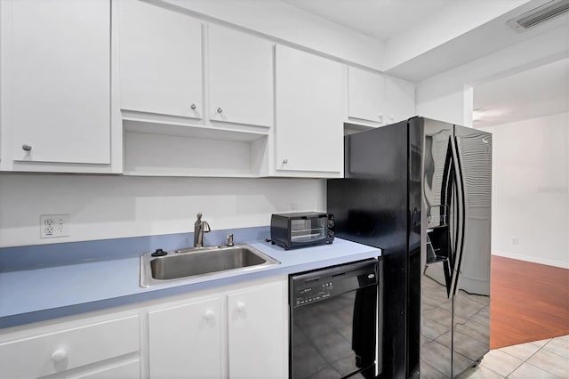 kitchen featuring light hardwood / wood-style flooring, black appliances, white cabinets, and sink