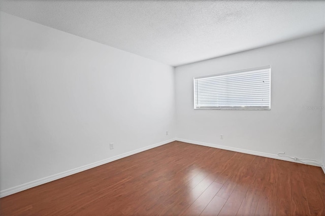 unfurnished room featuring a textured ceiling and hardwood / wood-style floors