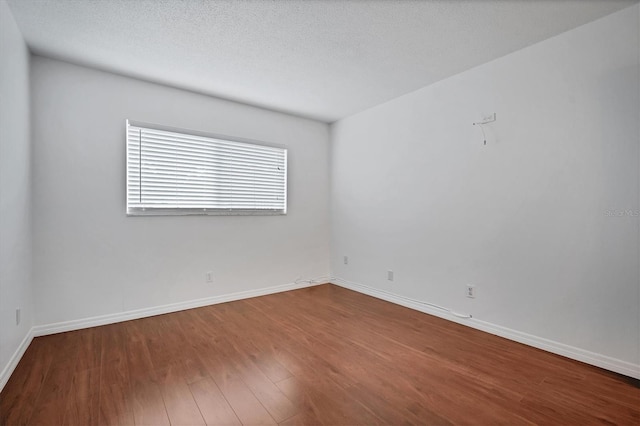 empty room featuring hardwood / wood-style floors and a textured ceiling