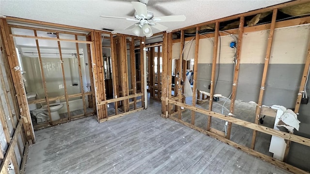 miscellaneous room with ceiling fan and a textured ceiling