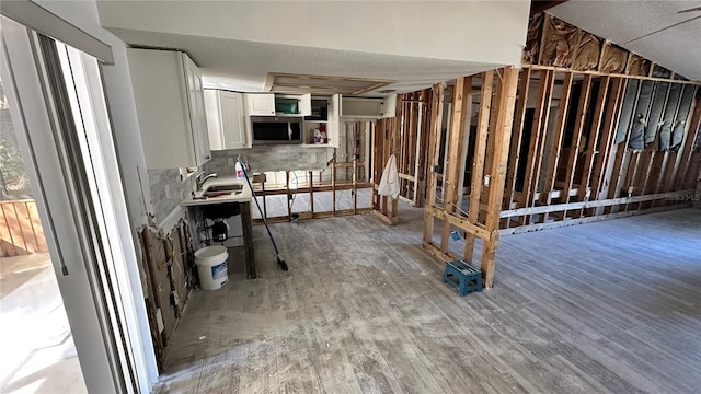 kitchen featuring sink, hardwood / wood-style flooring, and white cabinets