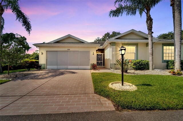 ranch-style home featuring a yard and a garage