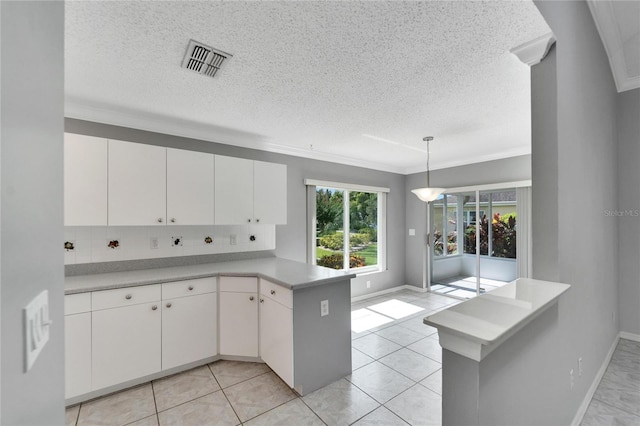 kitchen featuring white cabinets, decorative backsplash, kitchen peninsula, and hanging light fixtures