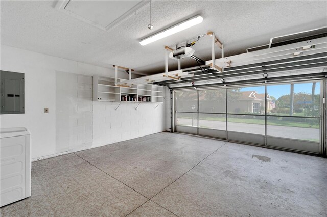 garage with electric panel, a garage door opener, and washer / clothes dryer