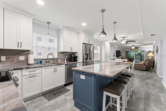 kitchen with ceiling fan, tasteful backsplash, sink, and stainless steel appliances