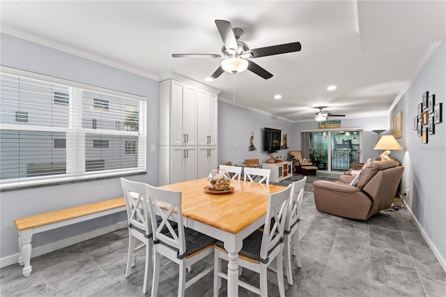 tiled dining space with ceiling fan and crown molding