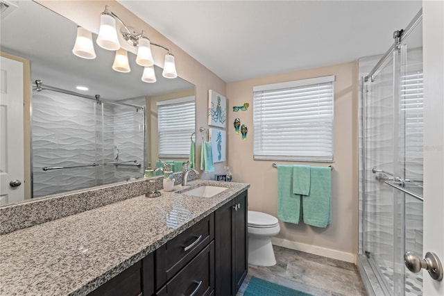 bathroom with an enclosed shower, toilet, vanity, and tile patterned floors