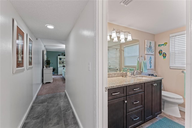 bathroom featuring toilet, vanity, tile patterned floors, walk in shower, and a textured ceiling