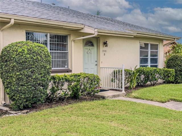 entrance to property with a lawn