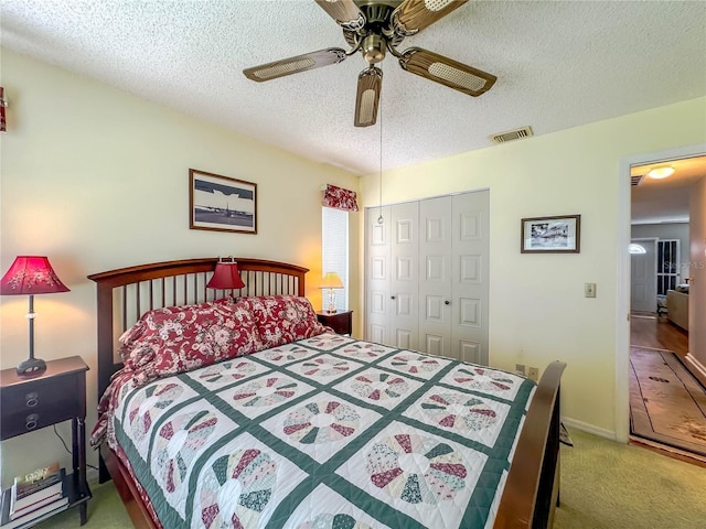 bedroom with ceiling fan, carpet floors, a textured ceiling, and a closet