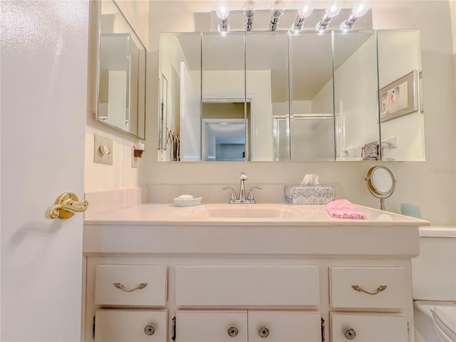 bathroom featuring toilet, an enclosed shower, and vanity