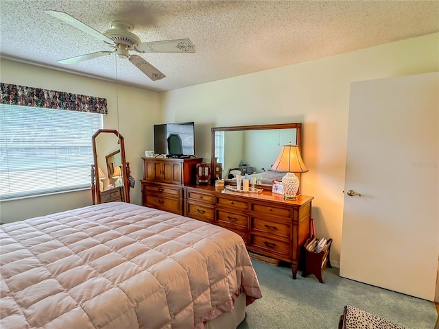 carpeted bedroom featuring a textured ceiling and ceiling fan