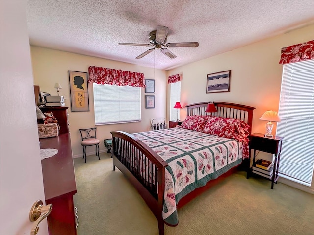 carpeted bedroom with ceiling fan and a textured ceiling