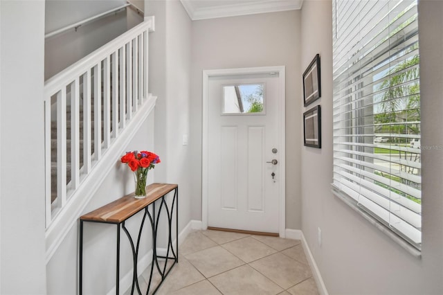 entrance foyer with light tile patterned floors, baseboards, stairs, and crown molding