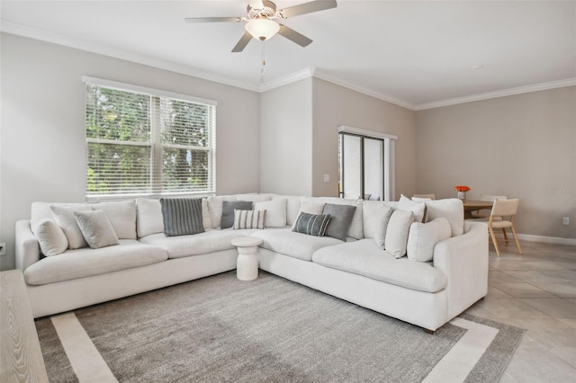 living area with light tile patterned floors, baseboards, a ceiling fan, and crown molding