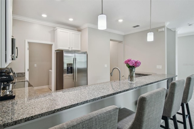 kitchen featuring appliances with stainless steel finishes, pendant lighting, and white cabinets