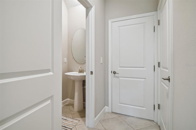 half bathroom featuring baseboards and tile patterned floors