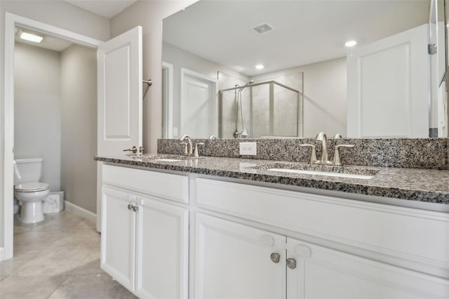 bathroom featuring visible vents, a sink, a shower stall, and double vanity