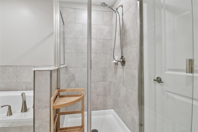 bathroom with a shower stall and a bath