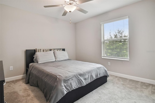 bedroom with light carpet, ceiling fan, and baseboards