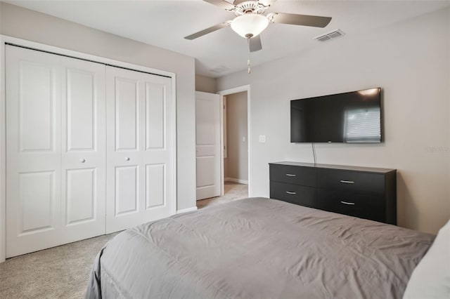 bedroom featuring ceiling fan, visible vents, a closet, and light colored carpet