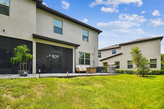 back of property with an outdoor hangout area, a lawn, a sunroom, and stucco siding