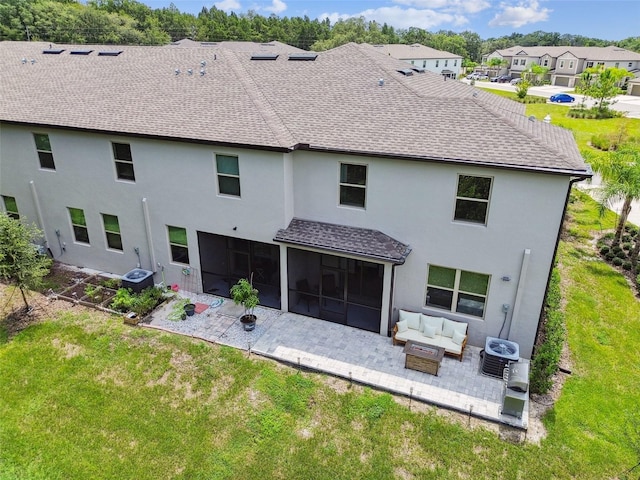 back of house featuring a sunroom, an outdoor living space, roof with shingles, a residential view, and a patio area