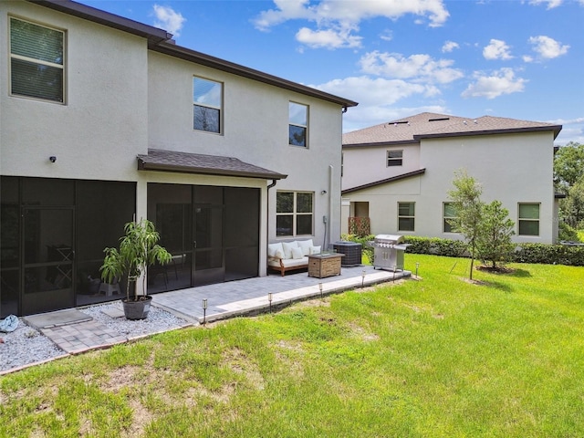 back of house featuring a patio, a sunroom, a yard, an outdoor living space, and stucco siding