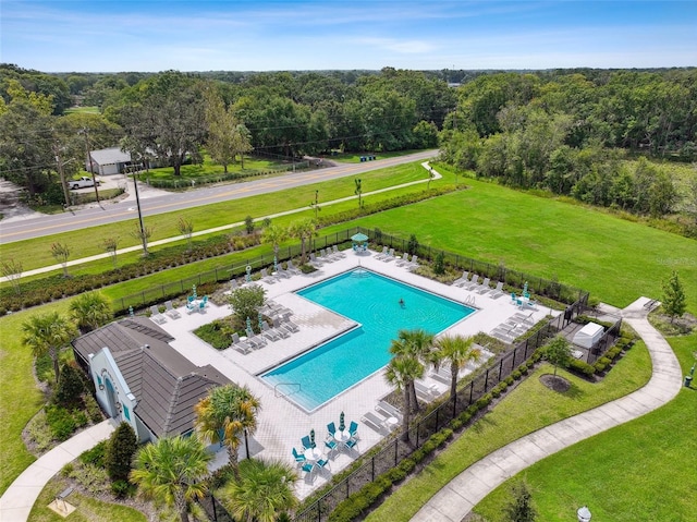 community pool featuring fence and a wooded view