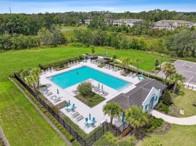 community pool with a yard, fence, and a patio