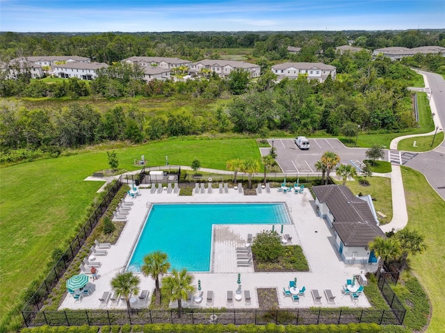 community pool featuring a residential view, fence, and a patio