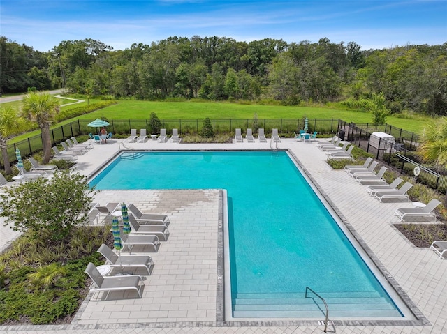 community pool featuring fence and a patio