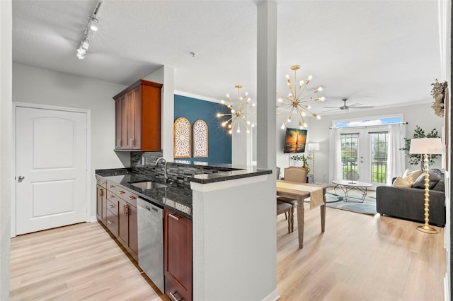 kitchen with ceiling fan with notable chandelier, light hardwood / wood-style floors, dishwasher, sink, and rail lighting