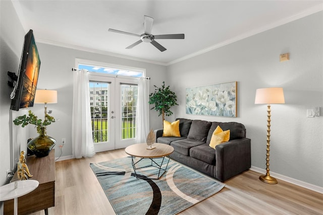 living room with ceiling fan, light hardwood / wood-style floors, crown molding, and french doors