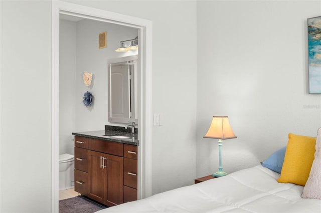 bedroom featuring sink, tile patterned flooring, and ensuite bath