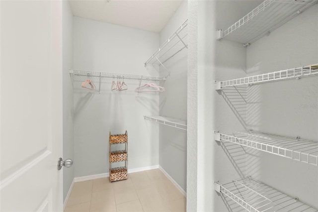 spacious closet featuring light tile patterned floors